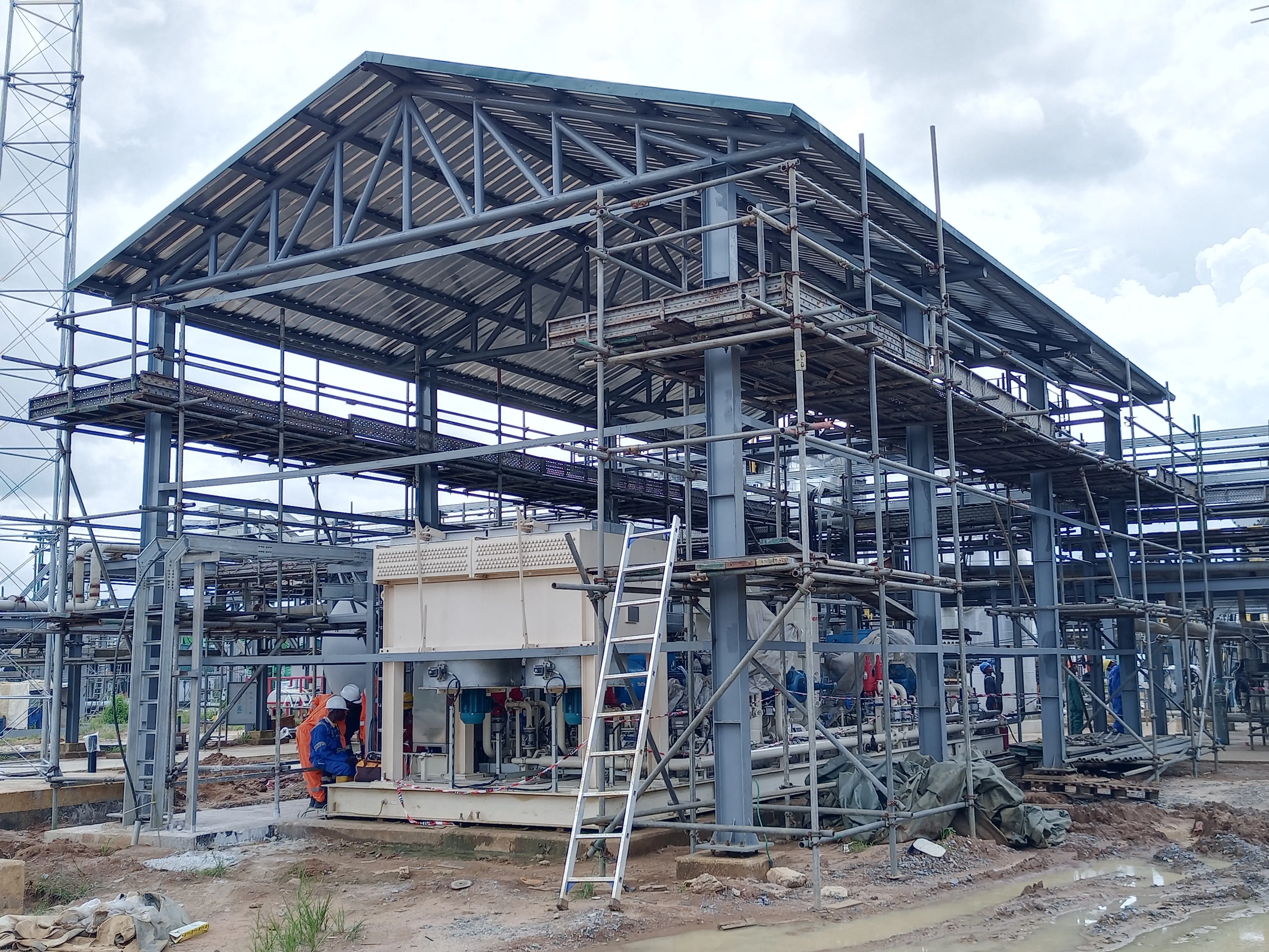 A worker in protective gear welding a metal pipe
